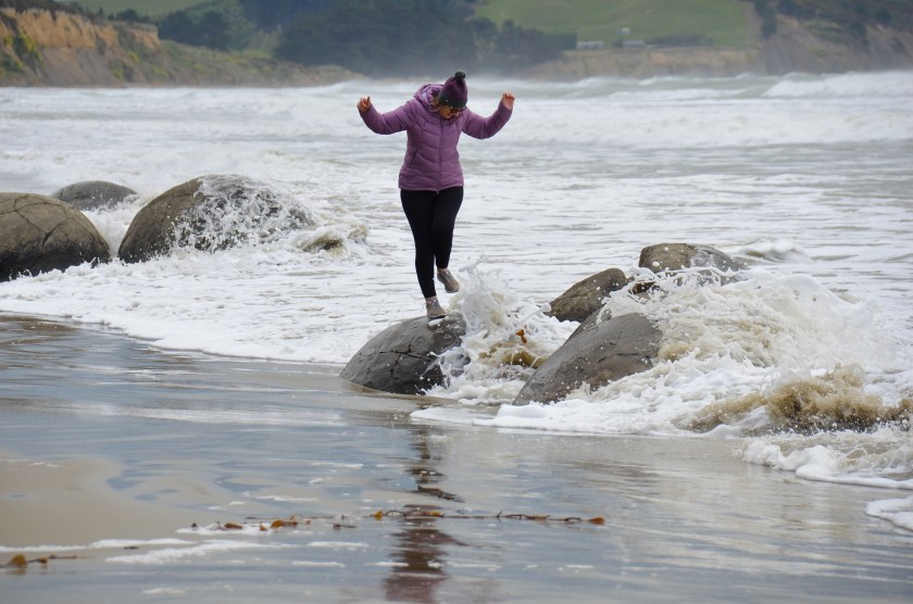 Getting hit by a wave on top of beach bowlders