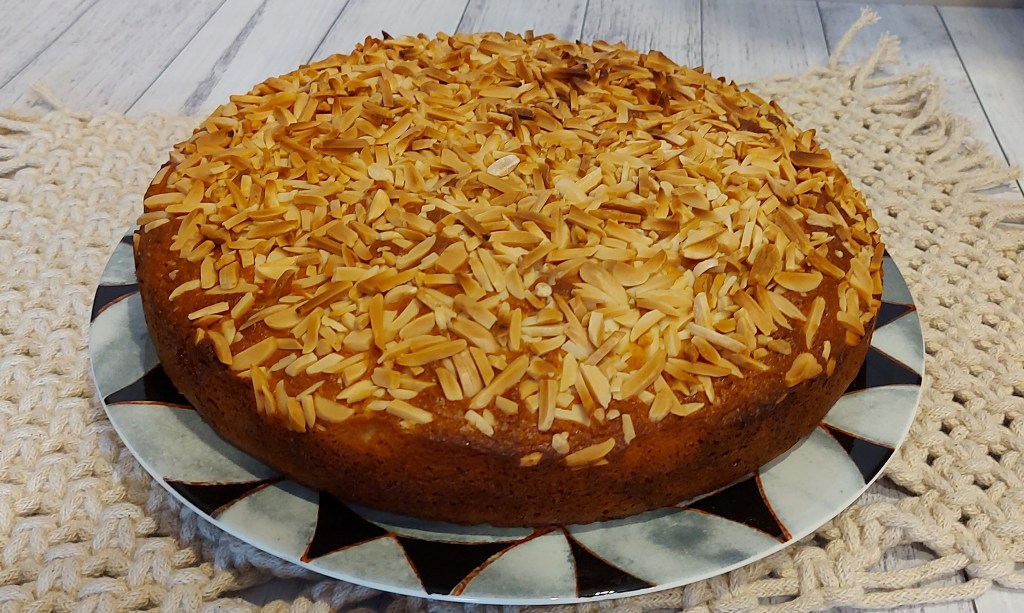 Buttery Almond Madeira Cake with a Crunchy Top fresh from the oven and ready on a plate to cut and enjoy.