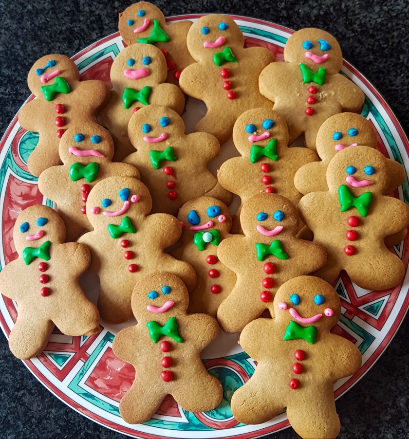 The cutest little plate of gingerbread men with green bow ties, red buttons, blue eyes and a big pink smile.