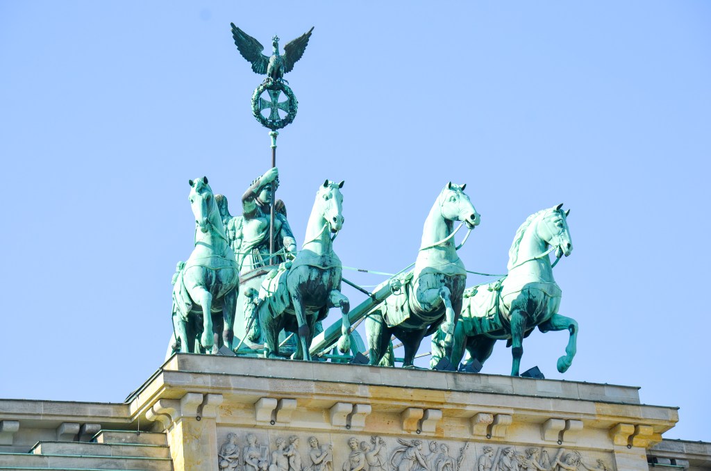 Statue of the Quadriga atop the Brandenburg Gate in Berlin, featuring a chariot drawn by four horses with a figure holding a staff and eagle.