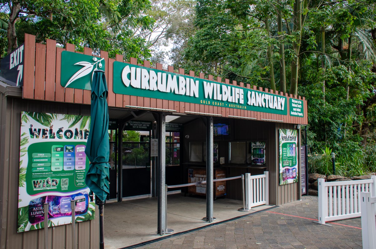 Entrance to Currumbin Wildlife Sanctuary in Gold Coast, Australia, featuring a welcoming sign and ticket information.