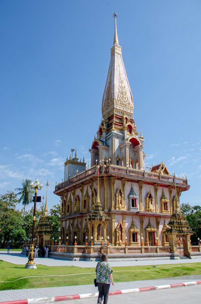 Ornate golden temple tower with intricate carvings under a clear blue sky